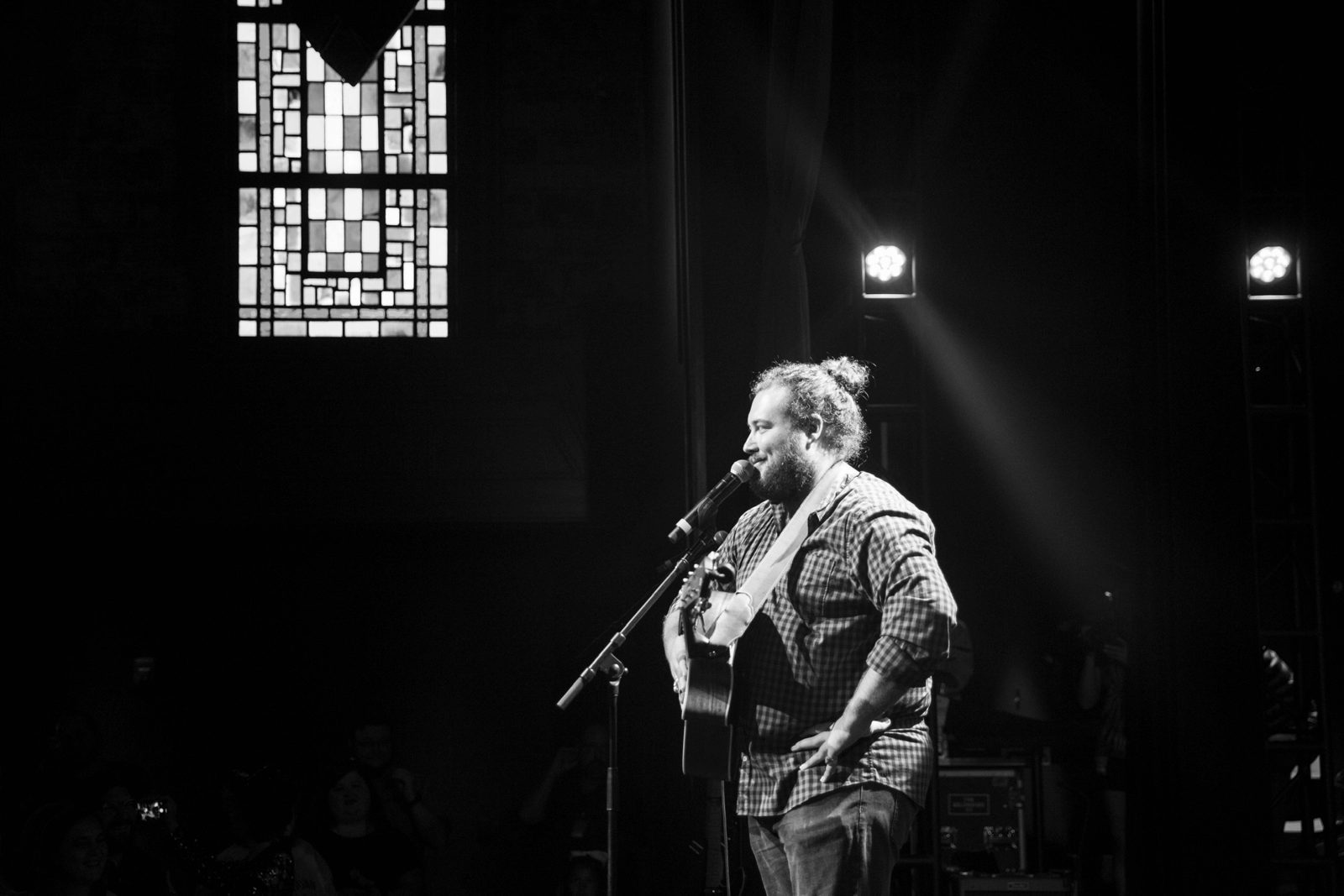 Graham DeFranco at the microphone in a spotlight, black and white — Instagram post by @grahamdefranco