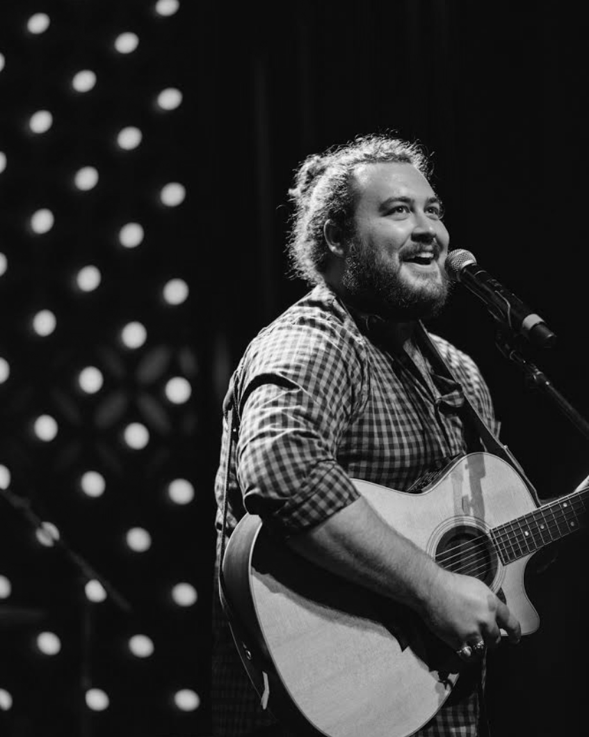 Graham DeFranco performing live with an acoustic guitar, black and white photograph