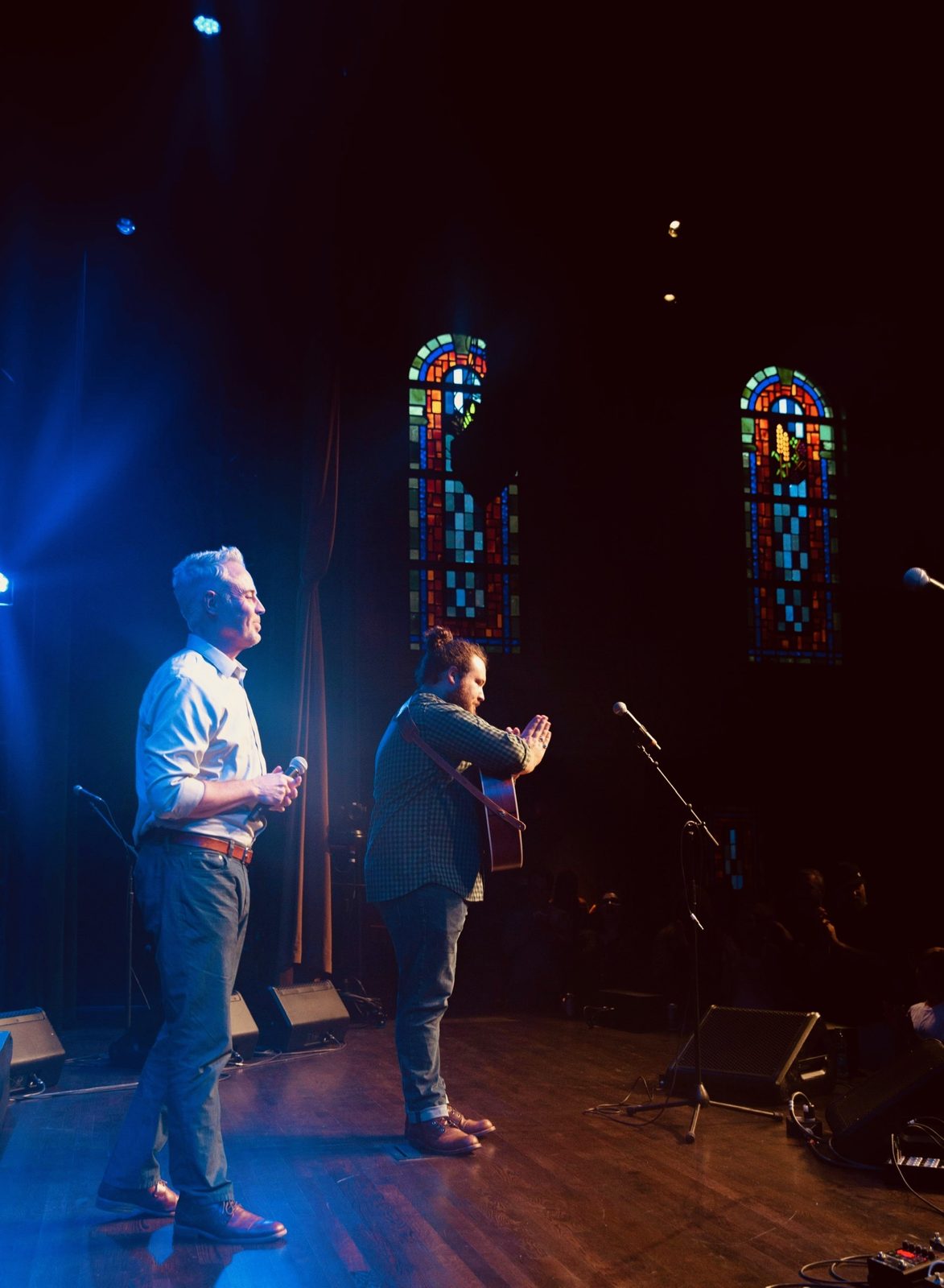 Graham DeFranco performing in a chapel venue with stained glass windows — Instagram post by @grahamdefranco